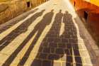 Romania-Brasov Shadowed figures in silhouette on street cobblestone Art Print